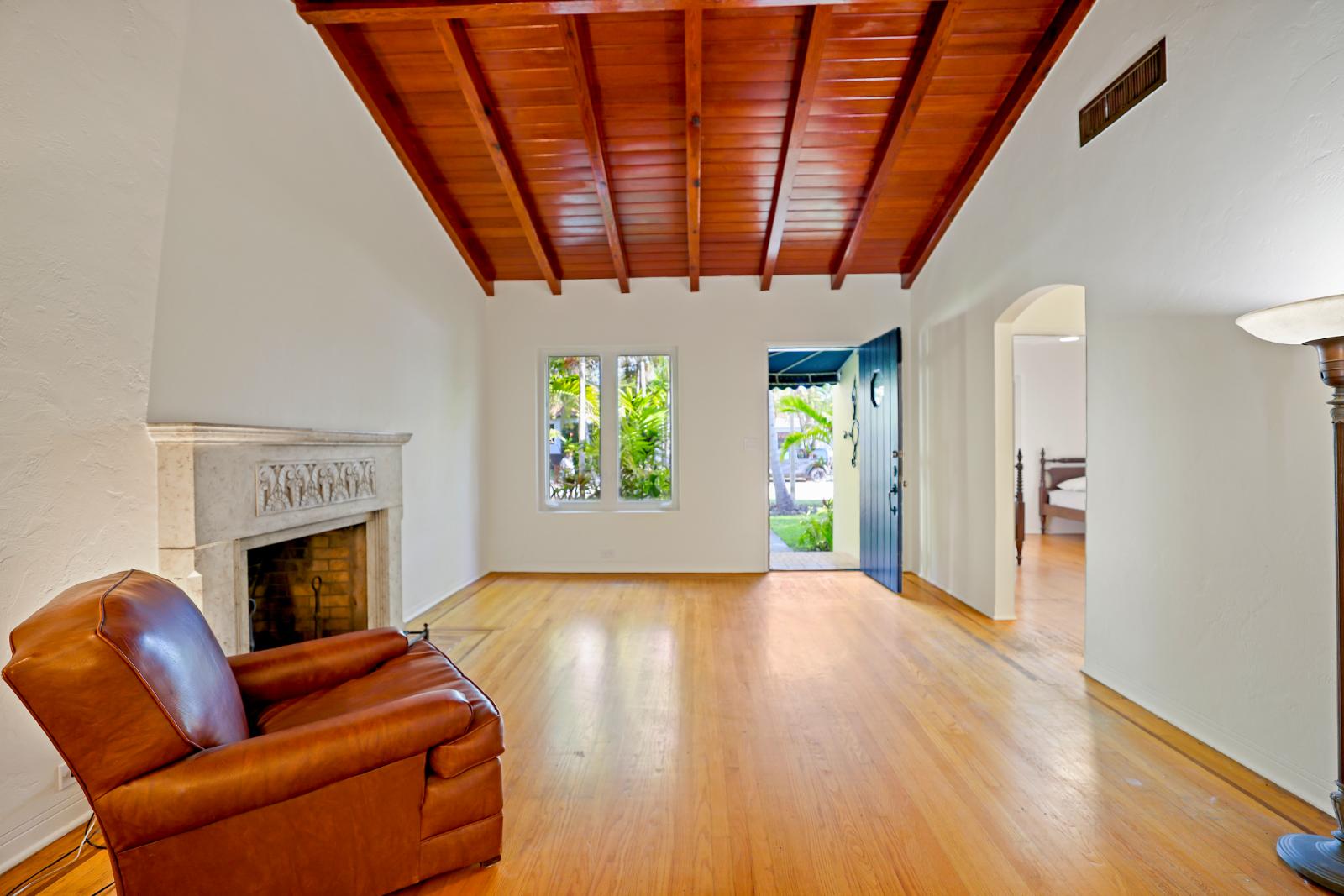 Living room with fireplace and warm wood ceiling detail