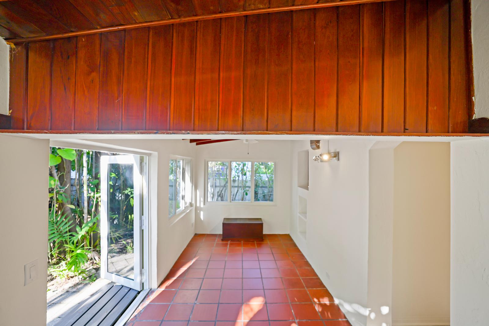 Sunroom with terracotta flooring and open garden-facing wall